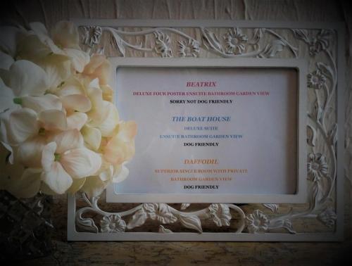 a framed diploma with white flowers on a wall at Puddle Duck Lodge – Adults Only in Bowness-on-Windermere
