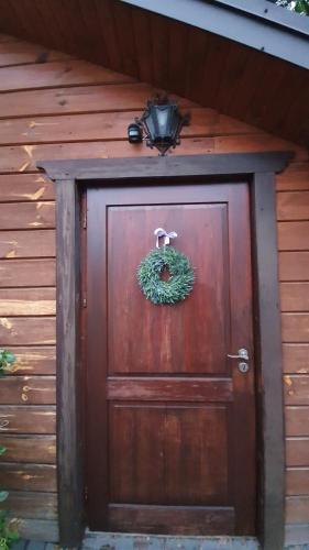 a brown door with a wreath on it at Karczma Regionalna Młyn -pokoje gościne in Zwierzyniec