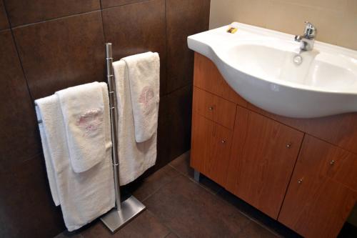 a bathroom with a white sink and towels at Casa D'avo in Geres