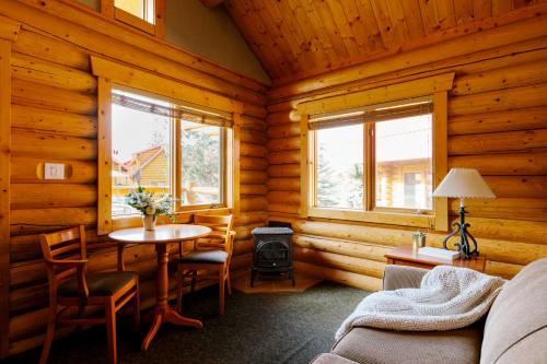 a living room with a table in a log cabin at Miette Mountain Cabins in Jasper