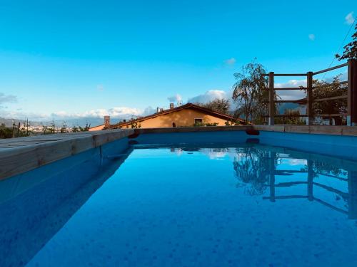 una piscina de agua azul frente a una casa en Casa Emma Fiattone in Garfagnana, en Fiattone