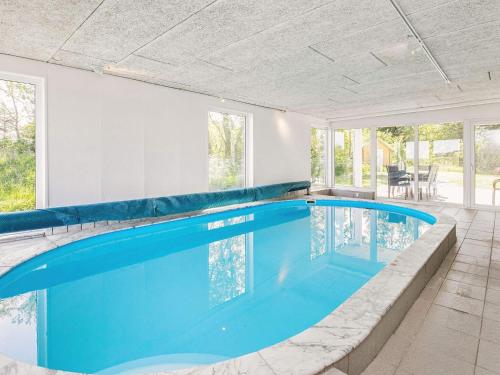 an indoor swimming pool with blue water in a house at 10 person holiday home in Hals in Hou