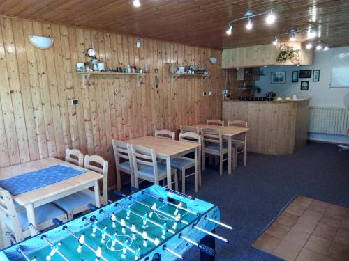 ein Restaurant mit Holzwänden, Tischen und Stühlen in der Unterkunft Apartmány NIVA in Široká Niva