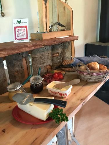 a table with a cutting board with bread and vegetables at The Old Henhouse in Tollarp