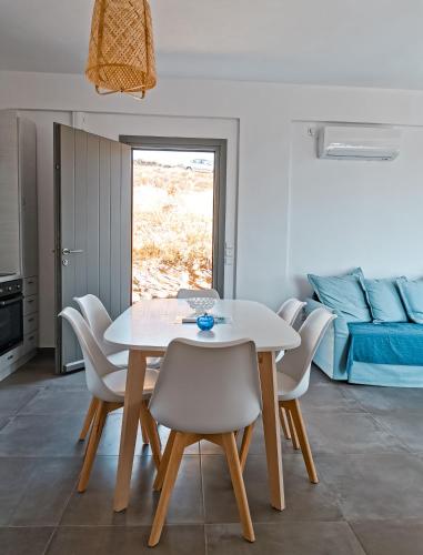 a dining room with a table and chairs and a bed at Αλός αήρ suites in Kithnos
