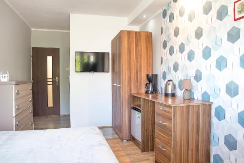 a bedroom with a bed and a dresser and a refrigerator at Pokoje Gościnne in Kołobrzeg