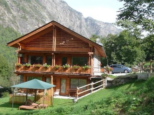 a small house in a field with a mountain at La Maison du Guide in Rhemes-Saint-Georges