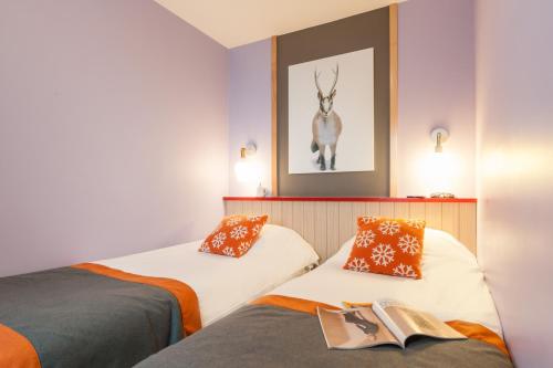 Deux lits dans une chambre avec une photo d'un cerf sur le mur dans l'établissement Résidence Pierre & Vacances Electra, à Avoriaz