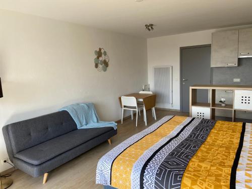a bedroom with a bed and a couch and a table at Apartment Bel-Air in Knokke-Heist