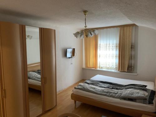 a bedroom with a bed and a mirror and a window at Ristorante Adria in Gloggnitz