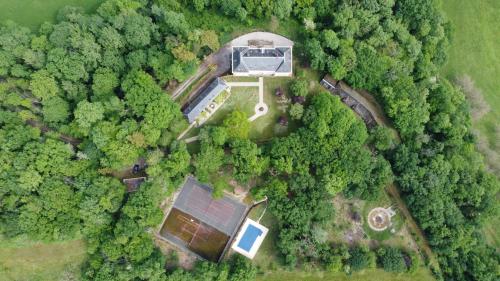 une vue aérienne d'une maison dans la forêt dans l'établissement La Chapelle du Chateau Lagarrigue, à Strenquels