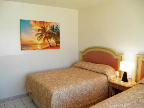 a hotel room with two beds and a painting on the wall at #52 Bungalow Seaside Hotel & Victors RV Park in San Felipe