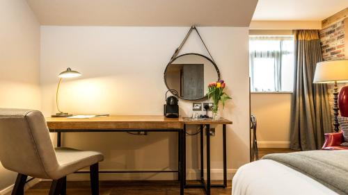 a hotel room with a desk and a mirror at Hotel Indigo York by IHG in York