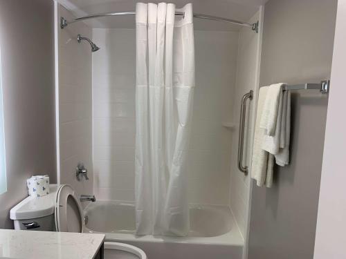 ein weißes Bad mit einer Dusche und einem WC in der Unterkunft Motel 6 Rockford, Il in Rockford