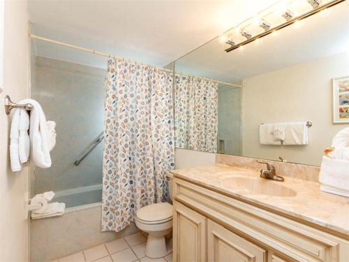 a bathroom with a toilet and a sink and a shower at Island Echos 4th-5th Floor Condos in Fort Walton Beach