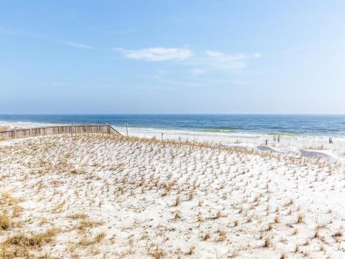 a sandy beach with a fence and the ocean at Islander Condominiums I in Fort Walton Beach