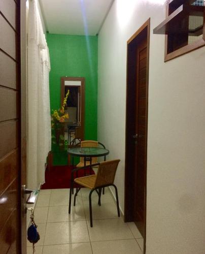 a room with a table and chairs and a green wall at Ruta Del Sol in Mossoró