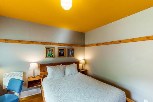 sypialnia z białym łóżkiem i niebieskim krzesłem w obiekcie Tacoma's Sweet Suite w mieście Tacoma