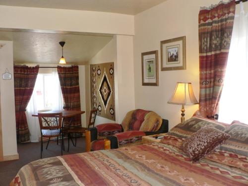 Schlafzimmer mit einem Bett, einem Schreibtisch und einem Tisch in der Unterkunft Alpaca Inn in Lava Hot Springs