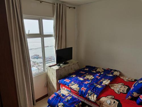a bedroom with a bed with mickey mouse sheets and a window at 2 Bed Room Amazing Sea View Condo 80sqm Fast Internet in Jakarta