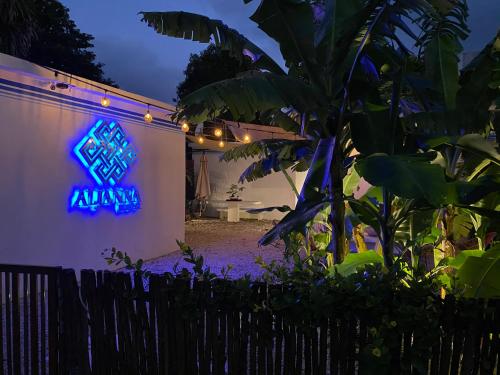 a blue sign on the side of a house at night at Aljanna House in Bacalar