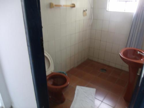 a bathroom with a toilet and a sink at Pousada Edson in Caraguatatuba