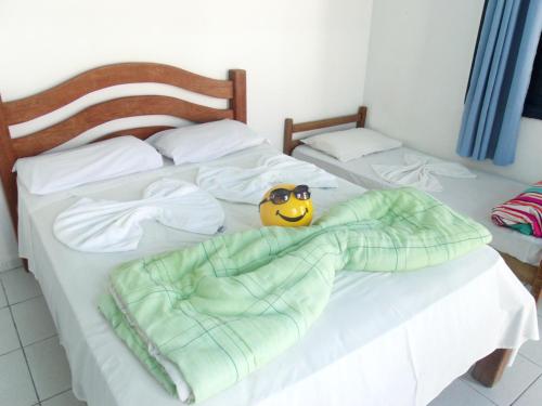 a bed with a smiley face with sunglasses on it at Pousada Edson in Caraguatatuba