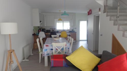 a dining room and kitchen with a table and chairs at Casa Férias Melides in Melides
