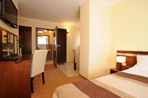 ニエホジェにあるAmericanoのベッドとデスクが備わるホテルルームです。