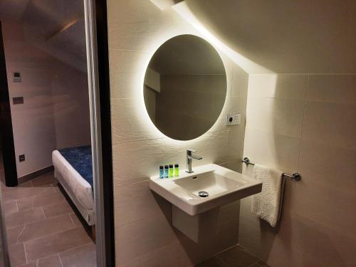 a bathroom with a sink and a mirror at Solpor do Coído in Muxia