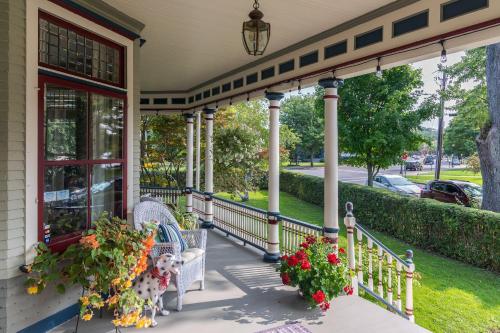 a porch of a house with two chairs and flowers at 2W Lake in Skaneateles