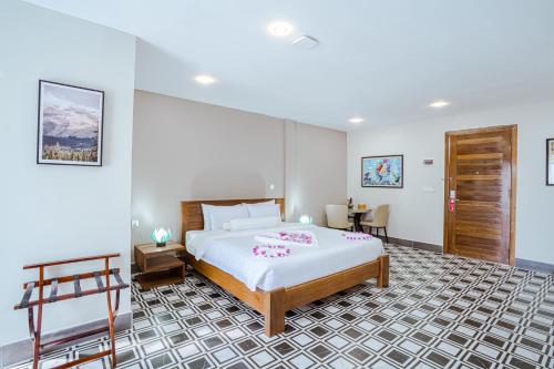 a bedroom with a large bed and a table at CALAO Kep Residence Hotel in Kep