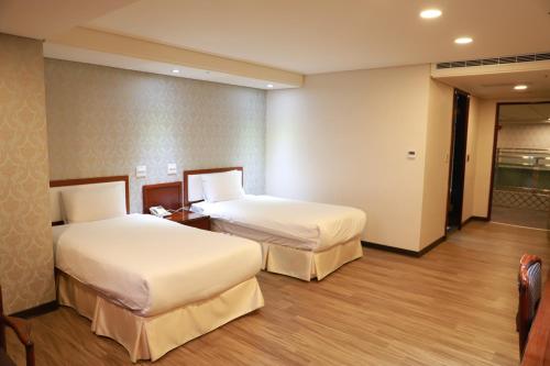 a hotel room with two beds in a room at Chuan Fu Hotel in Fengyuan
