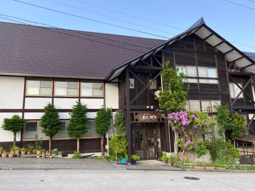 a black and white building with flowers and plants at Villa Kubota in Nozawa Onsen