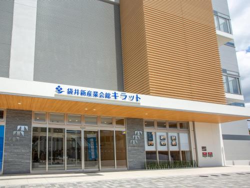a building with a sign on the front of it at Kuretake Inn Premium Fukuroi Ekimae in Fukuroi