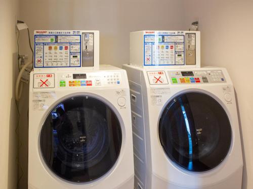two washing machines sitting next to each other at Kuretake Inn Premium Fukuroi Ekimae in Fukuroi