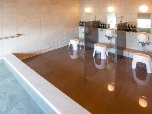 a bathroom with four urinals in a room at Kuretake Inn Premium Fukuroi Ekimae in Fukuroi