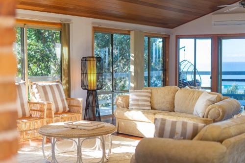 a living room with a couch and a table at Seascape @ 19 Pindari - privacy, space, views in Dunbogan