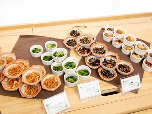 a table topped with plates of food and bowls of food at Kuretake Inn Premium Fukuroi Ekimae in Fukuroi