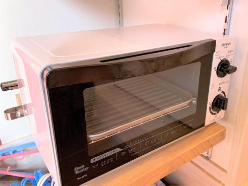 a microwave oven sitting on top of a shelf at Tomareru Himitsukichi L-Base in Matsumoto