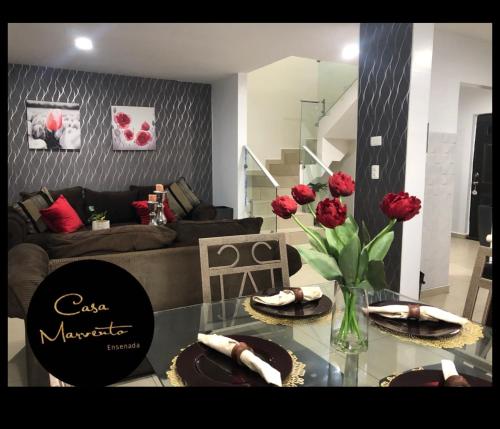 a living room with a glass table with red roses on it at Casa Marvento in Ensenada