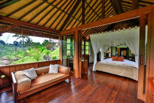 a bedroom with a bed and a couch in a room at Bagus Jati Health & Wellbeing Retreat in Tegalalang