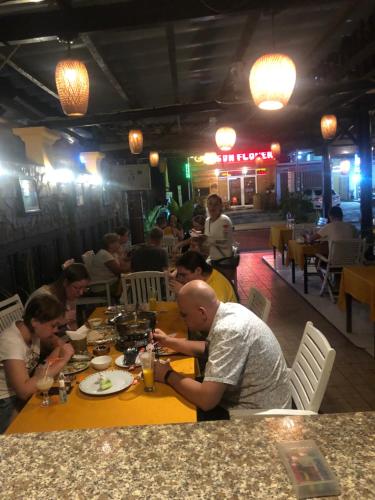 a group of people sitting at a table in a restaurant at Tulip Mui Ne in Phan Thiet