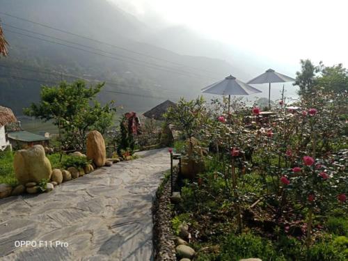 a garden with flowers and an umbrella on a mountain at Sapa Eco Villas & Spa in Sa Pa