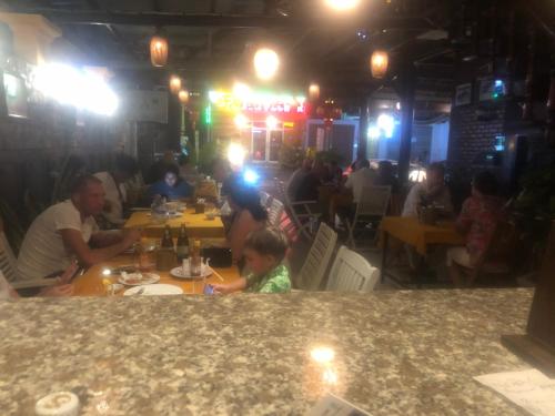 a group of people sitting at a table in a restaurant at Tulip Mui Ne in Phan Thiet
