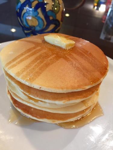 une pile de crêpes avec un morceau de beurre au dessus dans l'établissement Interchange Tower Serviced Apartment - SHA Extra Plus, à Bangkok