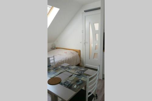 Kleines Zimmer mit einem Bett und einem Tisch in der Unterkunft Studio Cosy Douillet et Fonctionnel in Savigny-le-Temple