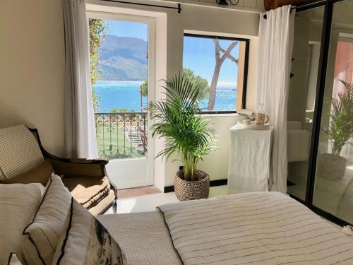 a bedroom with a bed and a large window at Le Jardin d'Emile in Cassis