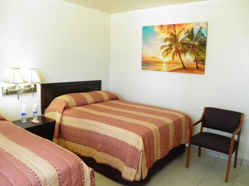 una habitación de hotel con 2 camas y una silla en #35 Bungalow Seaside Hotel & Victors RV Park, en San Felipe