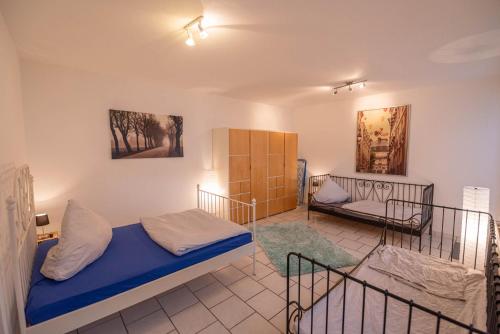 ein Schlafzimmer mit einem Bett und einer Couch in einem Zimmer in der Unterkunft 55m² 2 Zimmer-Monteurswohnung mit 4 einzelnen Betten in Nieder-Saulheim